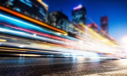 Long exposure shot of cars driving on a city road at night