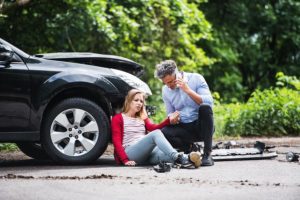 man and woman sitting on the floor after a car accident