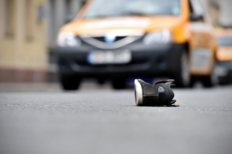 photo of shoe on the ground in front of a car