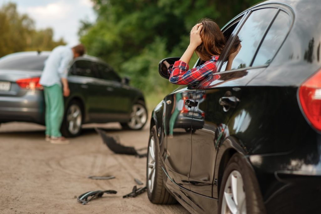 woman leaning out car window after accident