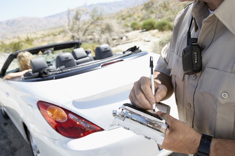 police officer writing ticket for woman who was pulled over