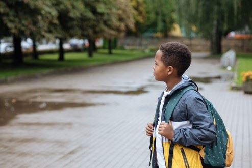 little boy waiting to cross the street