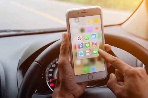 man driving and using his phone at the same time